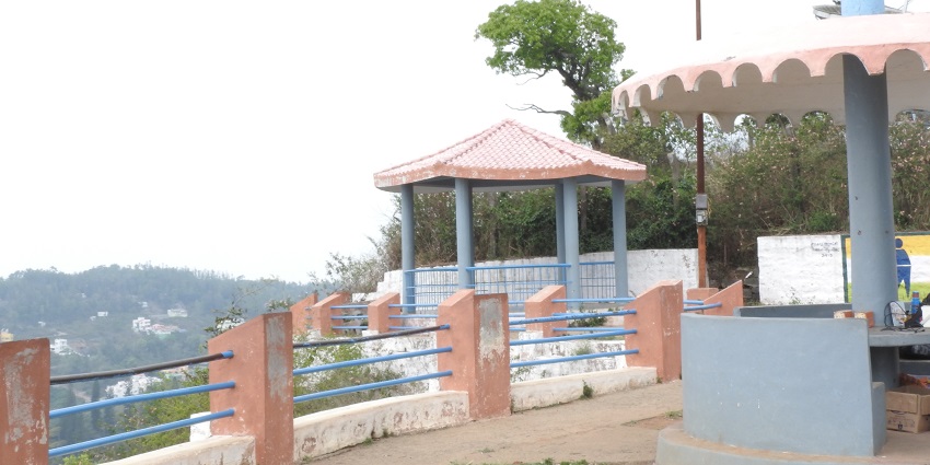 A group of men standing at the Gent’s seat viewpoint with another man talking on a call.