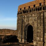 A panoramic view of a Ghangad fort, with the clear blue sky in the backdrop