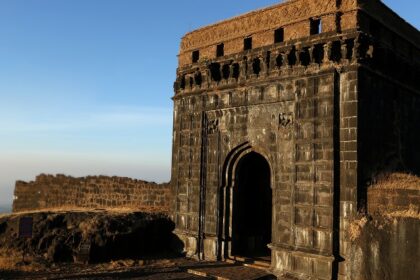 A panoramic view of a Ghangad fort, with the clear blue sky in the backdrop