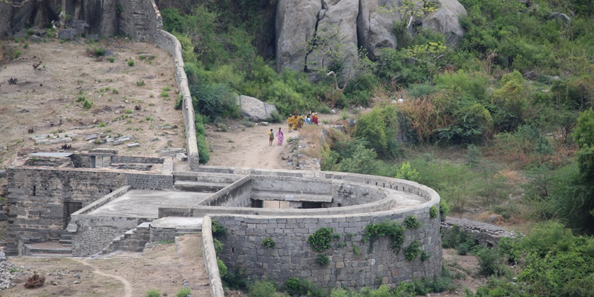 Top view of Gingee Fort with lush greenery in the background and few people leaving.