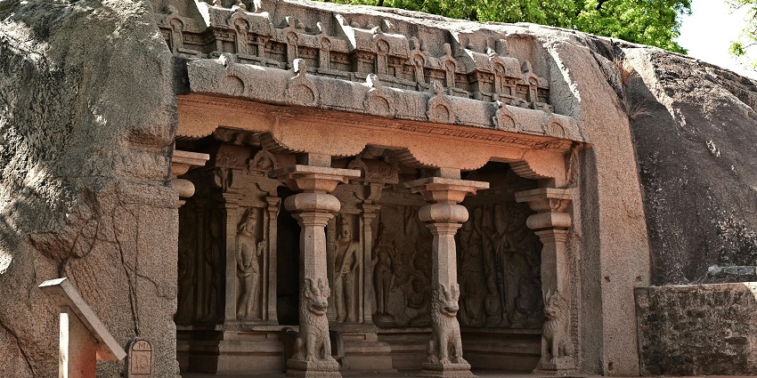 An ancient rock-cut temple in Mahabalipuram with sculptures carved on the stone pillars.
