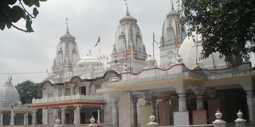 An image of Gorakhnath Temple which is white and has several domes and huge pillars.