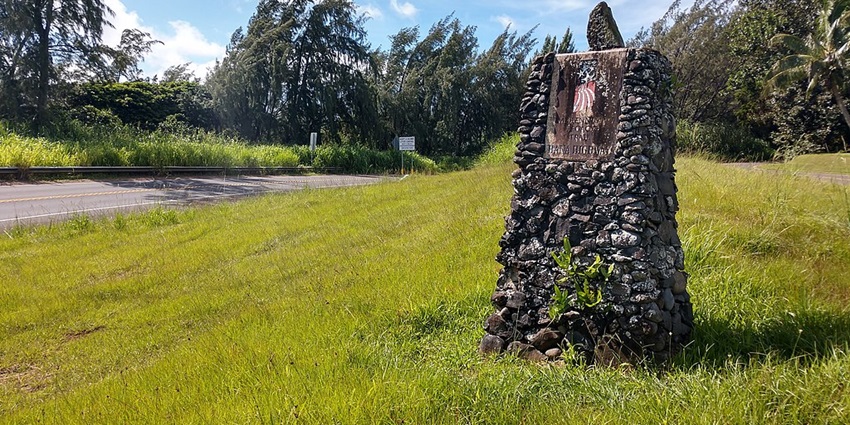 Hana Highway Millennium Trail monument built with stones and signboards in the background