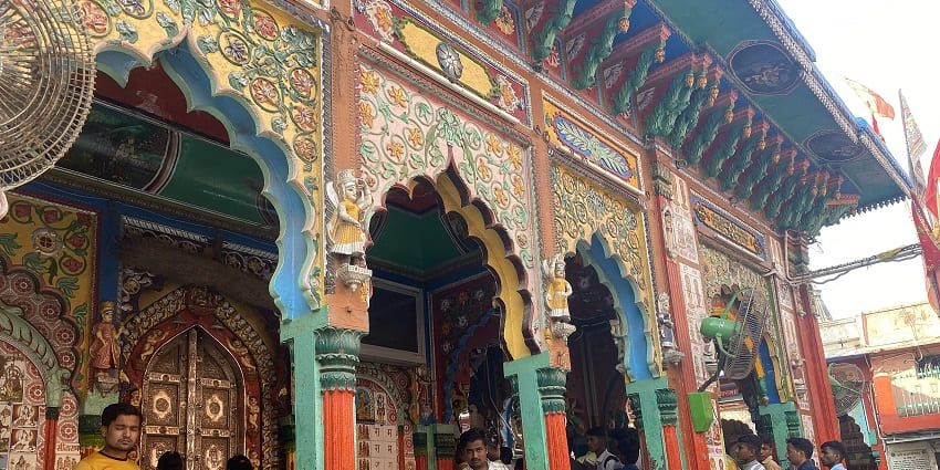 A picture of the entrance of a temple in Naimisharanya with bright and colourful walls