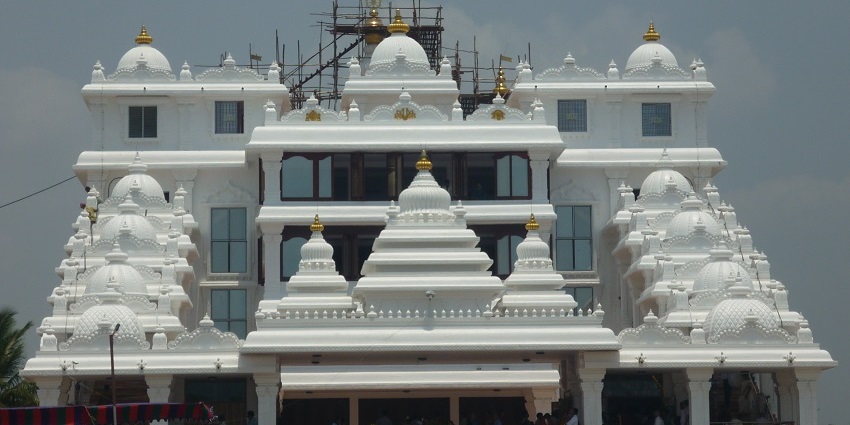 Shri Hare Krishna Temple in Chennai with white domes and golden finials, cars in front.