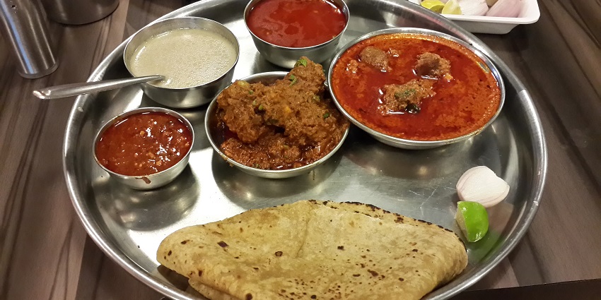 The thali contains non-vegetarian food which is a street food in Thane, Maharashtra.