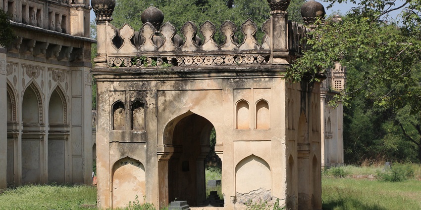 Image of the Hemu’s Samadhi Sthal surrounded by lush greenery in broad daylight.