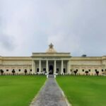 A view of the IIT Roorkee building surrounded by lush greenery grass field under blue sky