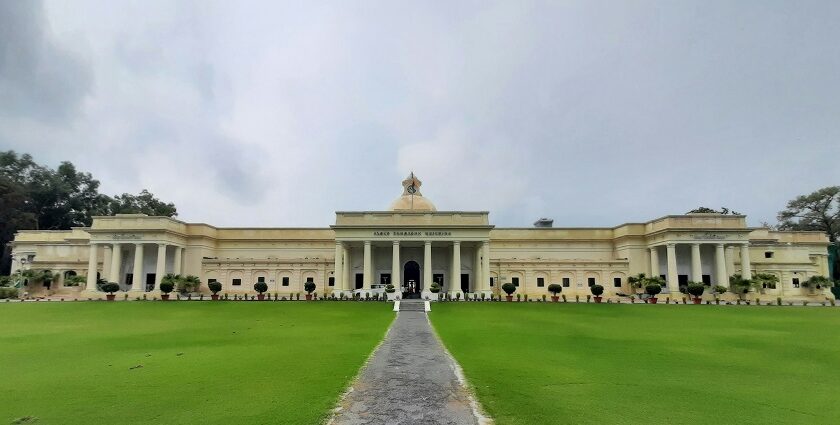 A view of the IIT Roorkee building surrounded by lush greenery grass field under blue sky