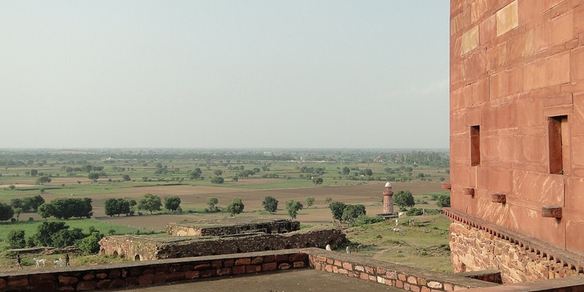 Image of Hiran MInar view far from the fort surrounded by lush greenery during day time