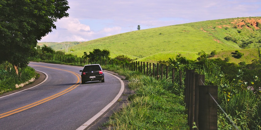 An image showcasing a car moving on a serene route towards Jalagamparai Waterfalls.