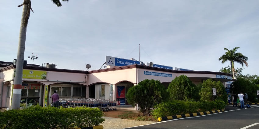 Outside view of the Airport of Salem, featuring entry gates, trolleys, and a snack shop.