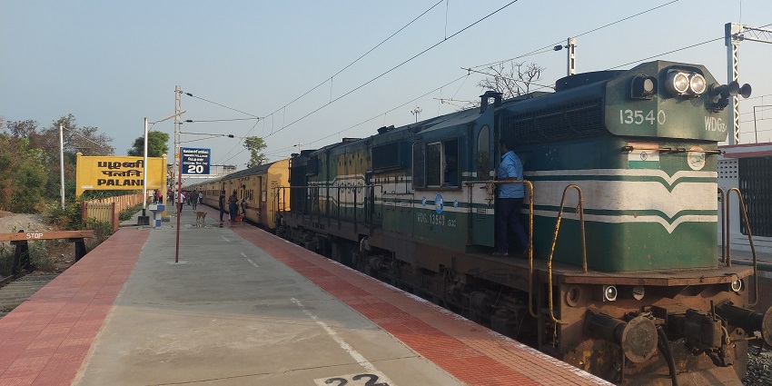Palani Railway station platform with people boarding and train operator going in his cabin