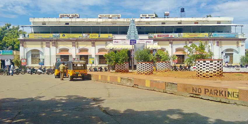 Thanjavur Junction entrance with signboard, people, and vehicles in front of the building.