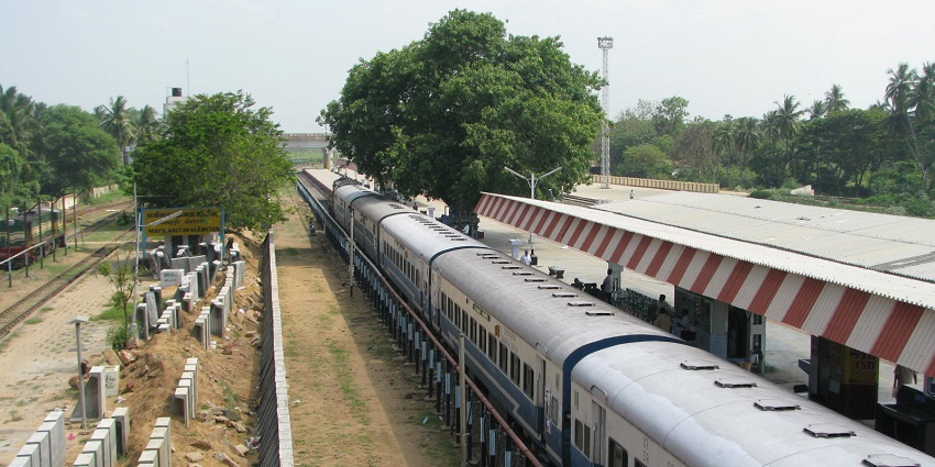Train at Mayiladuthurai Junction and platform with passengers boarding the train.