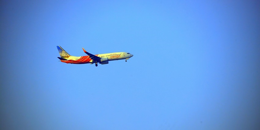 A scenic view of a plane in the sky from Pune International Airport near Bhairavgad Fort.