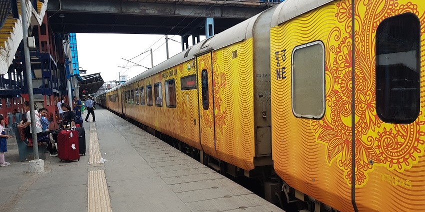 Image of Lucknow Railway Station and a train on the tracks during day time view