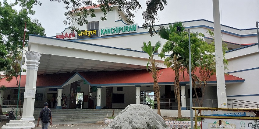 A yellow signboard with Kanchipuram written in three languages at the railway station.