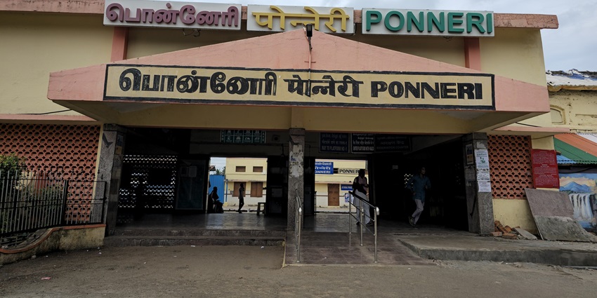 Ponneri Railway Station entrance with its archway, signage, and passengers entering.