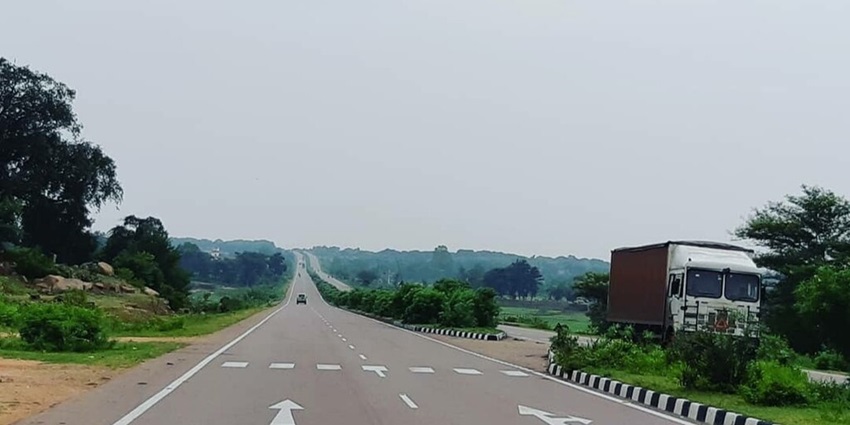 A road winding towards Barua Sagar Fort amidst greenery.