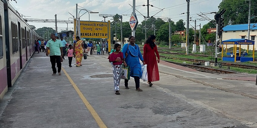 Chengalpattu railway station with a platform, railway tracks, train and passengers.