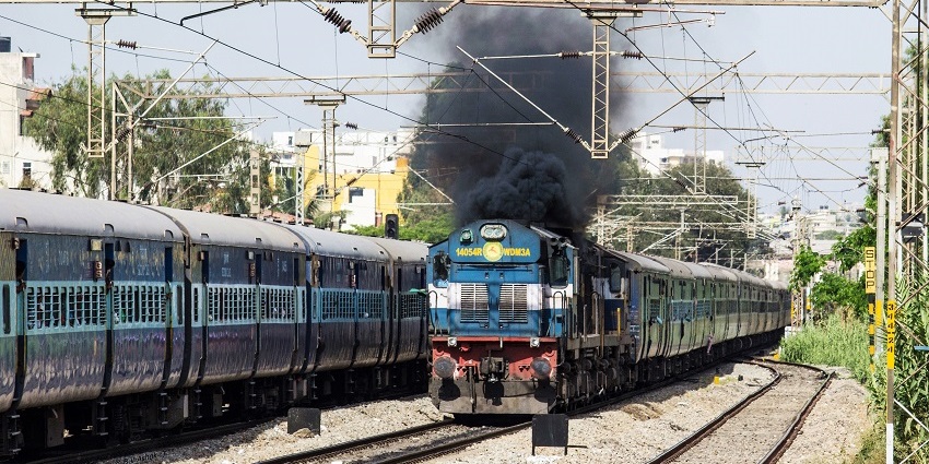 Coimbatore to LTT express train emitting smoke and moving next to another train.