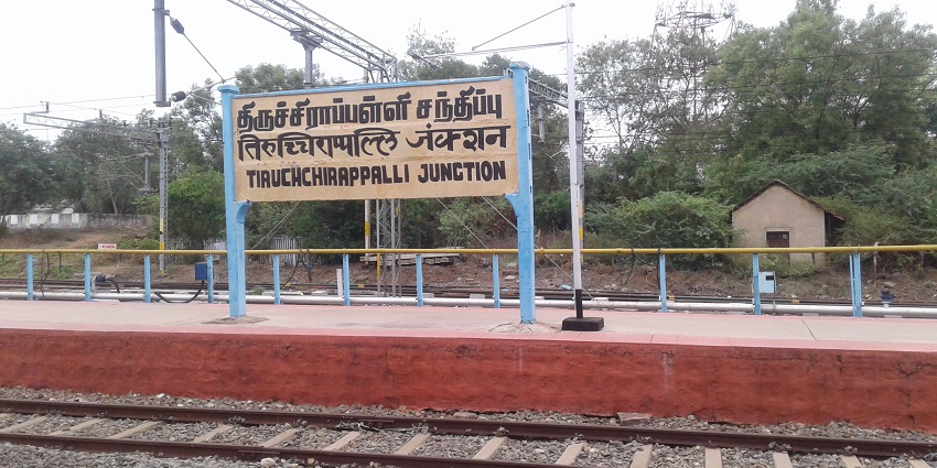 A Name Board of Tiruchirappalli Junction Railway Station with railway lines ahead.