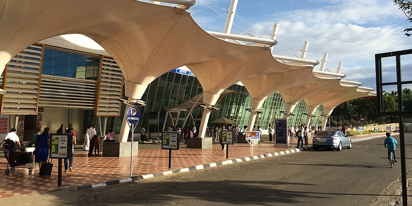 Coimbatore International Airport terminal building with parked vehicles in front.