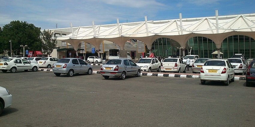 The exterior view of Coimbatore International Airport showcases the terminal building and surrounding landscape.