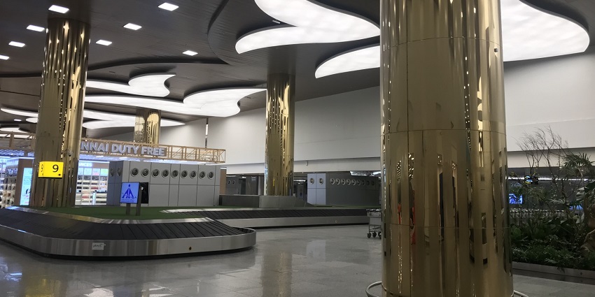 Inside view of an airport showcasing gold-coloured pillars at the arrival terminal