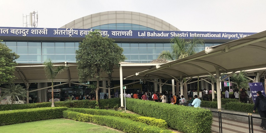 View of the entrance of Lal Bahadur Shastri Airport with a modern glass facade in Varanasi.