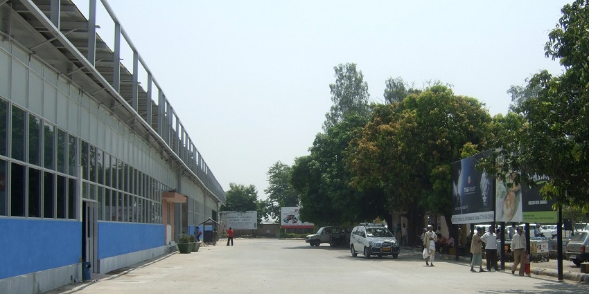 An exterior view of Varanasi Airport, featuring a modern terminal building with blue skies above.