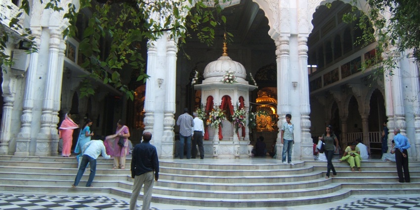 Beautiful altar inside ISKCON Juhu Temple decorated with idols and colorful floral arrangements