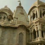 Vibrant Sri Krishna Balaram Mandir with ornate architecture, colorful decorations, and a lively atmosphere