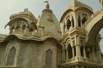 Vibrant Sri Krishna Balaram Mandir with ornate architecture, colorful decorations, and a lively atmosphere