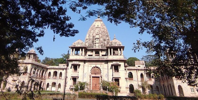 The temple’s entrance with carved pillars, devotees visiting the temple and a streetlight