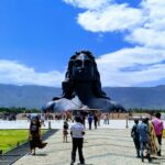 Isha Temple with the backdrop of the Velliangiri Mountains and clear blue skies.