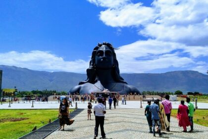 Isha Temple with the backdrop of the Velliangiri Mountains and clear blue skies.