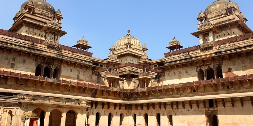 Front view of Jahangir Mahal in Orchha with arches, domes, and historic architecture.
