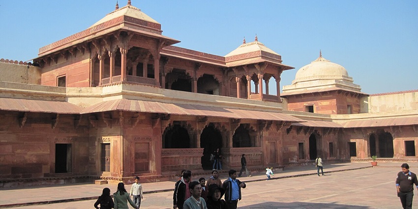 Image of Jodha Bai's Palace in Fatehpur Sikri where tourists are strolling around with their guides