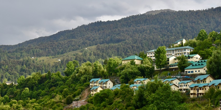 A breathtaking vista of Joshimath featuring towering mountains and lush greenery.