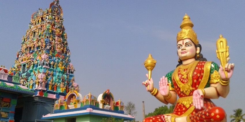 A statue of Goddess and the Gopuram of the Lord Shiva temple at Tamil Nadu.