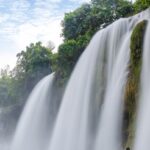 A vibrant view of flowing water of Kaalikesam Waterfalls from torrent amidst rocky terrain.