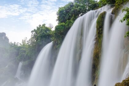 A vibrant view of flowing water of Kaalikesam Waterfalls from torrent amidst rocky terrain.