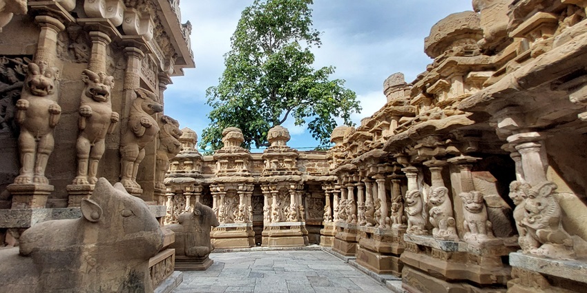 Kailasanathar Temple with people exploring the detailed carvings and stone architecture.