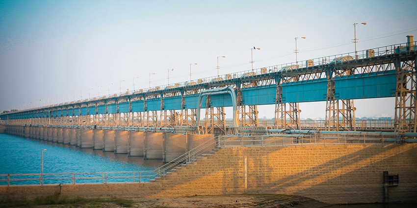 An image showing a white and grey bridge under a clear sky, similar to the Kalagarh Dam.