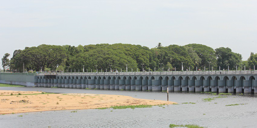 Kallani dam on the long stretch of Kaveri River with tall trees in the background