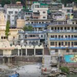 Kalpeshwar Temple shrine amidst mountains and lush greenery located in Uttarakhand.