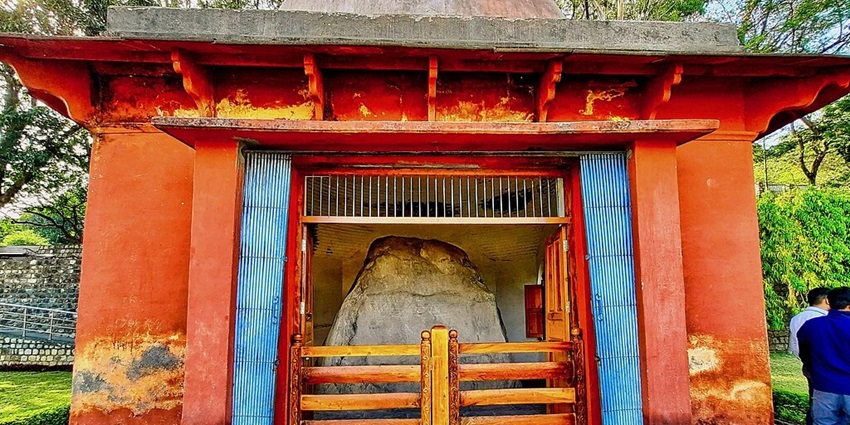 A picture of a historical temple with red walls, located near Dehradun