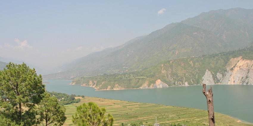 An image showing the scenic views surrounding Tehri Dam in Kanatal, Uttarakhand.